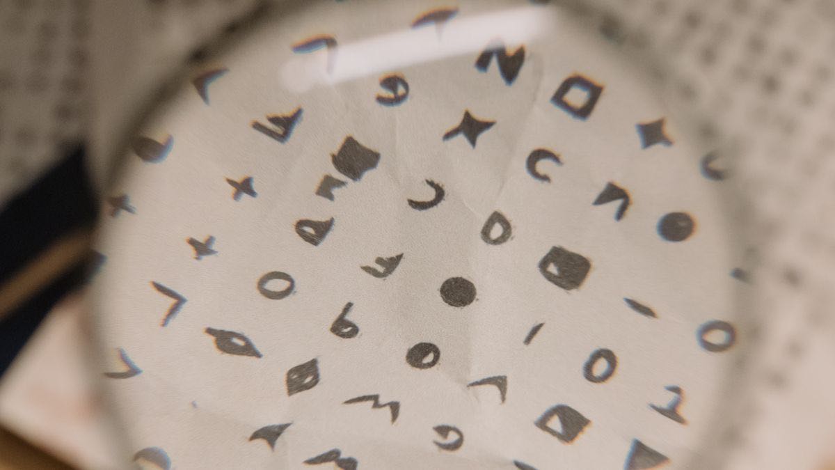 A magnifying lens held over a page of cryptic symbols, bringing them into focus — a metaphor for decoding AI rank tracker methodology
