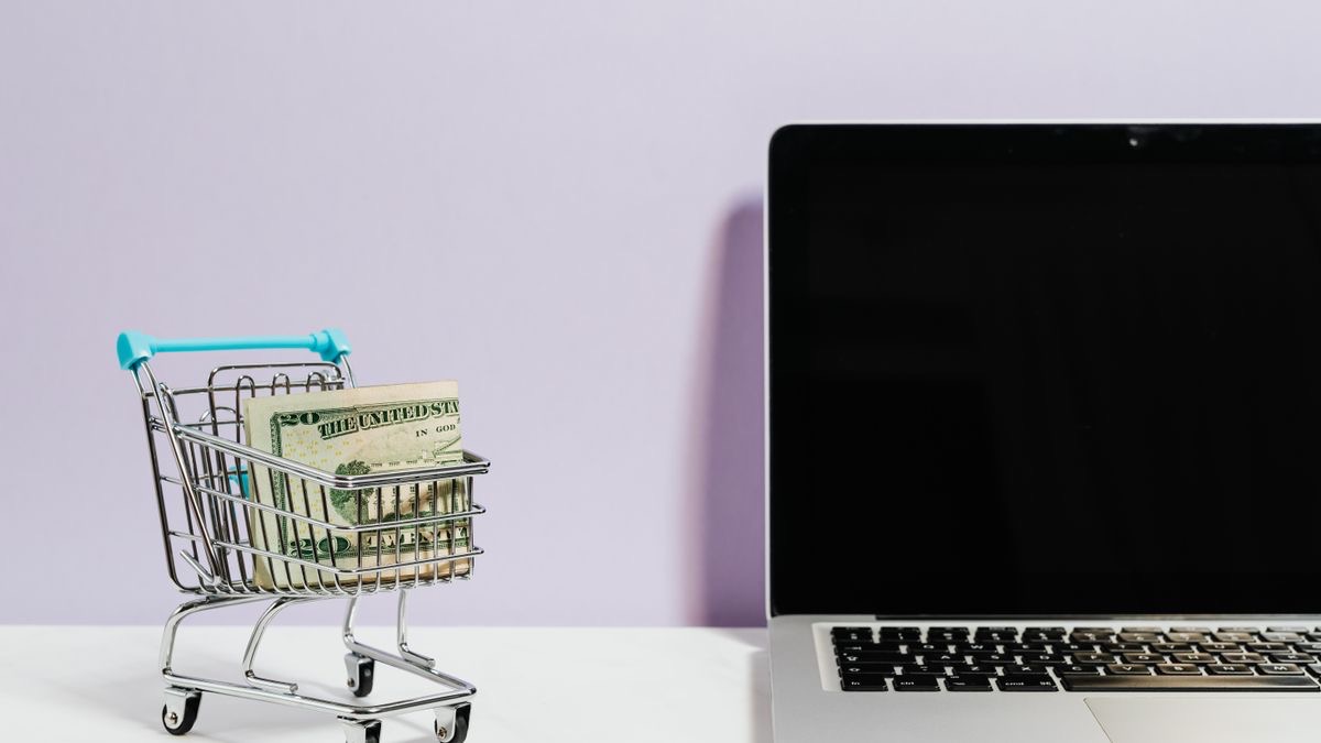 A shopping trolley icon on a computer screen beside a keyboard, representing the e-commerce product data an Amazon API returns