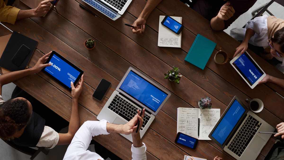 An agency team collaborating around a table with laptops, representing a white-label SERP API stack