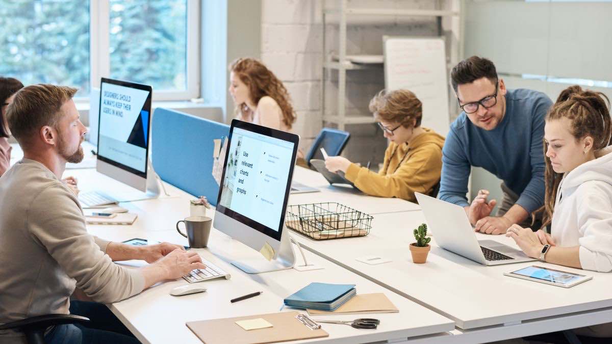 A team working at computers in a modern office, illustrating an agency running rank tracking for many clients