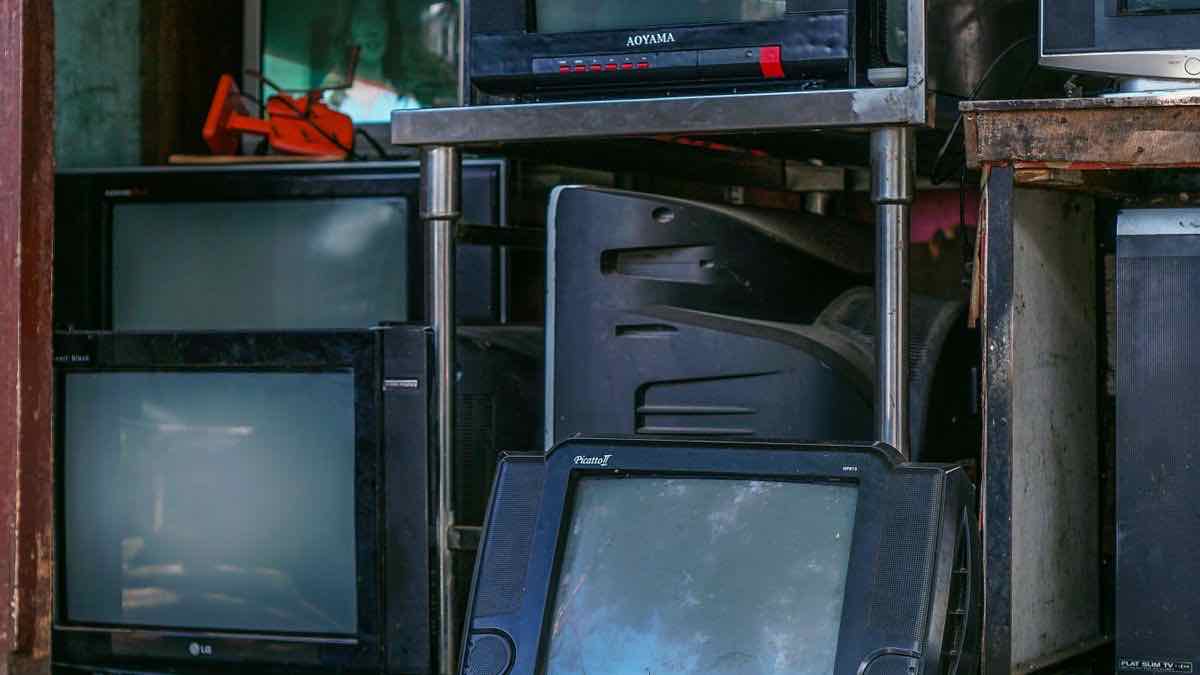 A crowded repair-shop shelf of old CRT and flat-screen televisions piled on metal racks, standing in for a pile of video results whose contents vary from row to row