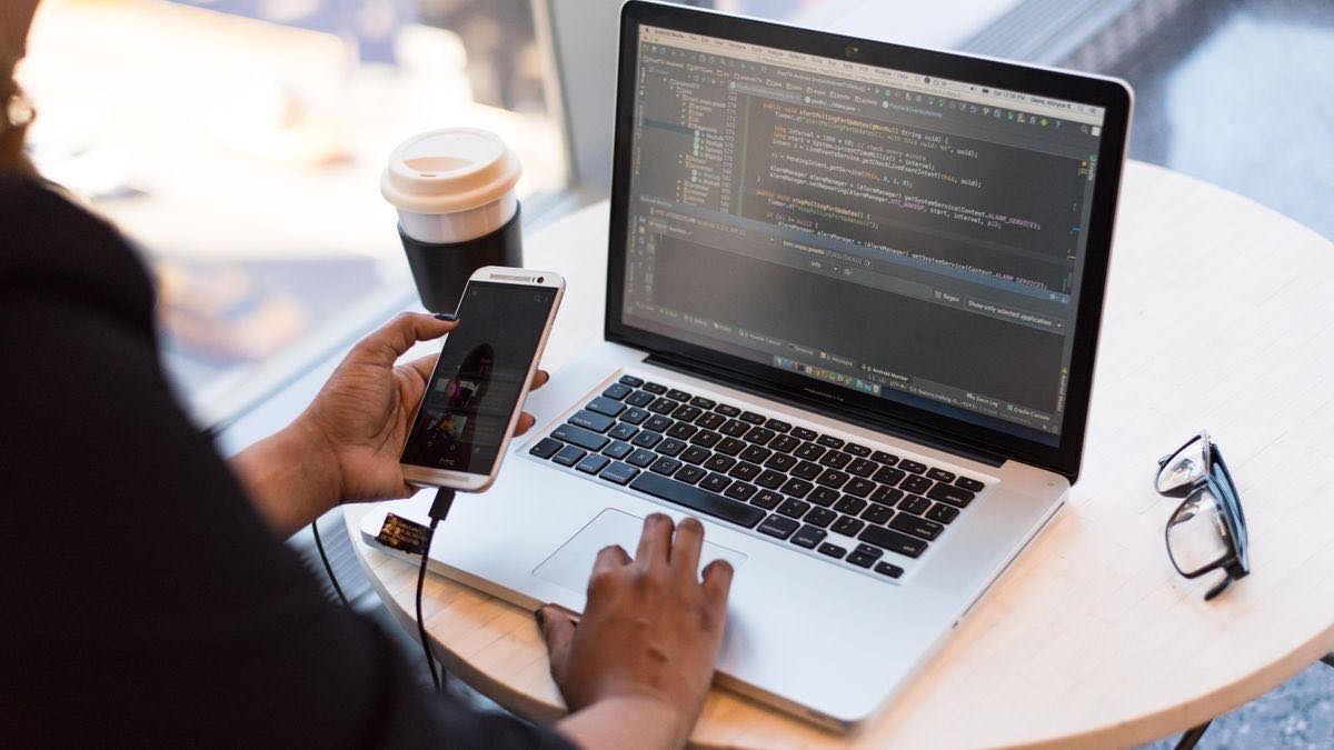 Python code on screen next to a coffee cup, representing building an AI visibility tracker