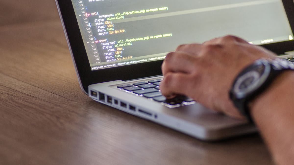 Hands typing on a laptop with code on the screen, the way you run the Python product call
