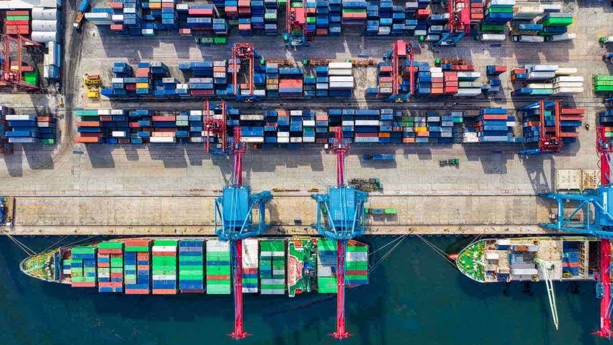 Aerial view of a container port moving thousands of containers in parallel — bulk throughput as a planning problem