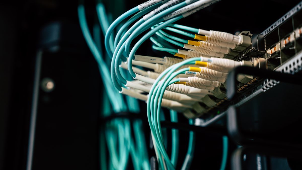 Teal fiber-optic network cables in a rack, representing scraping proxy bandwidth