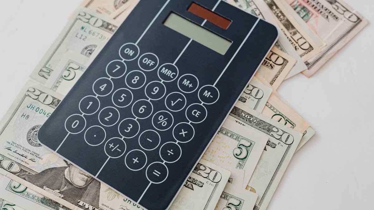 A pocket calculator lying on a spread of US dollar banknotes