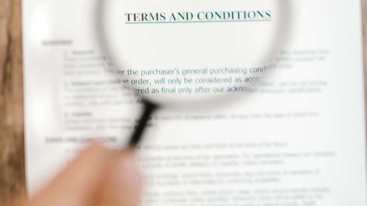 A magnifying glass held over a printed page headed Terms and Conditions