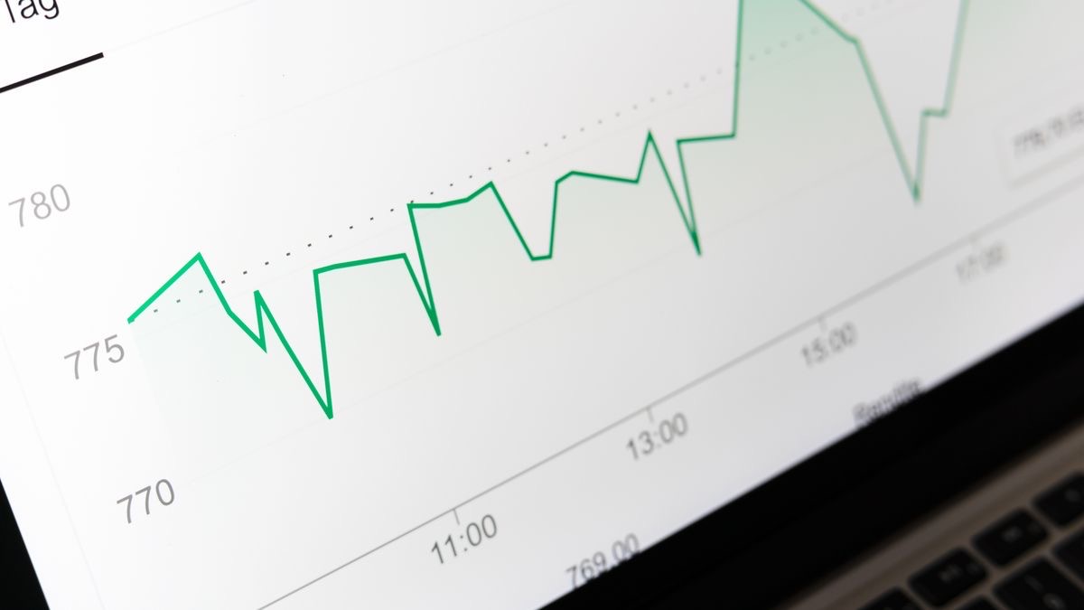 A close-up of a green line chart on a laptop screen with time labels along the bottom