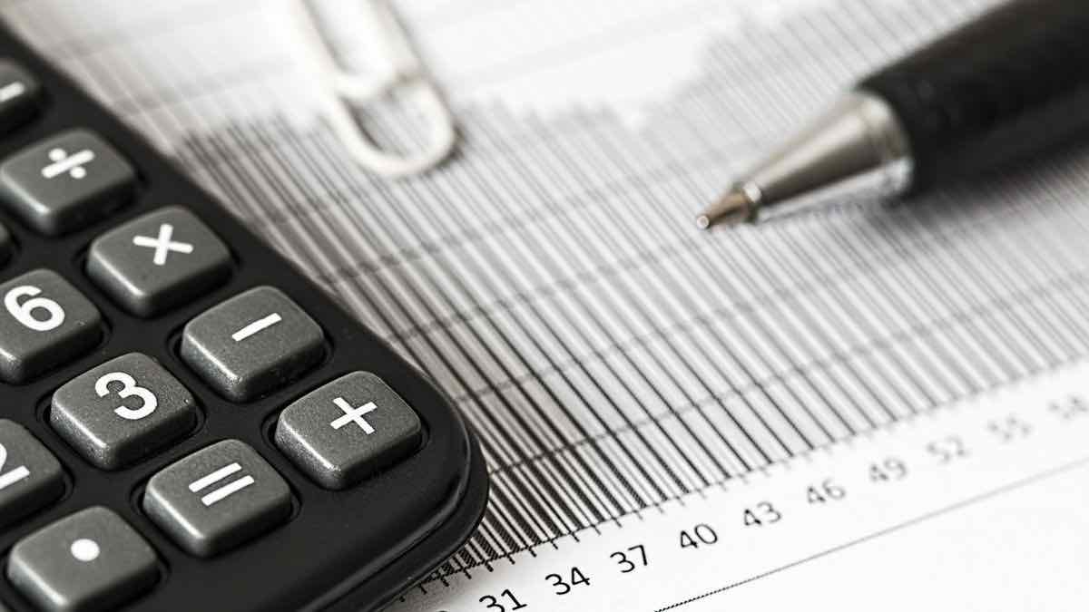 A black calculator and a pen resting on a printed chart