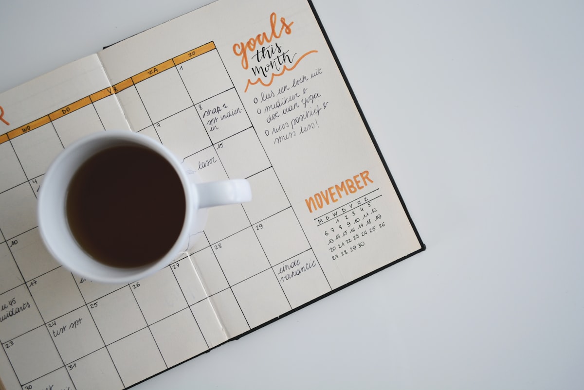 Open monthly planner with a coffee cup, representing the January 2027 migration deadline
