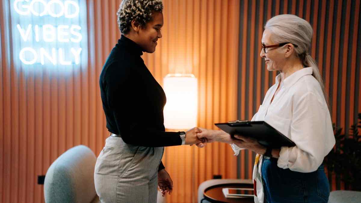 Two professionals shaking hands in an interview — the hiring activity behind the job postings the API returns