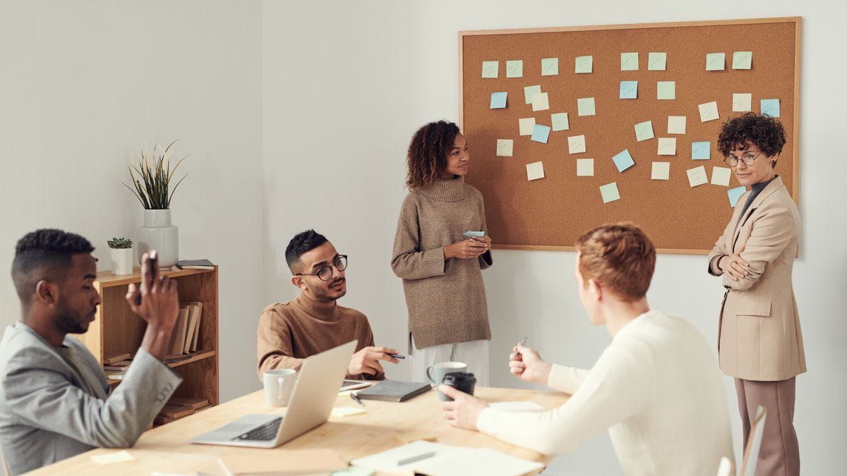 A team gathered at a whiteboard of sticky notes, choosing between two technical approaches