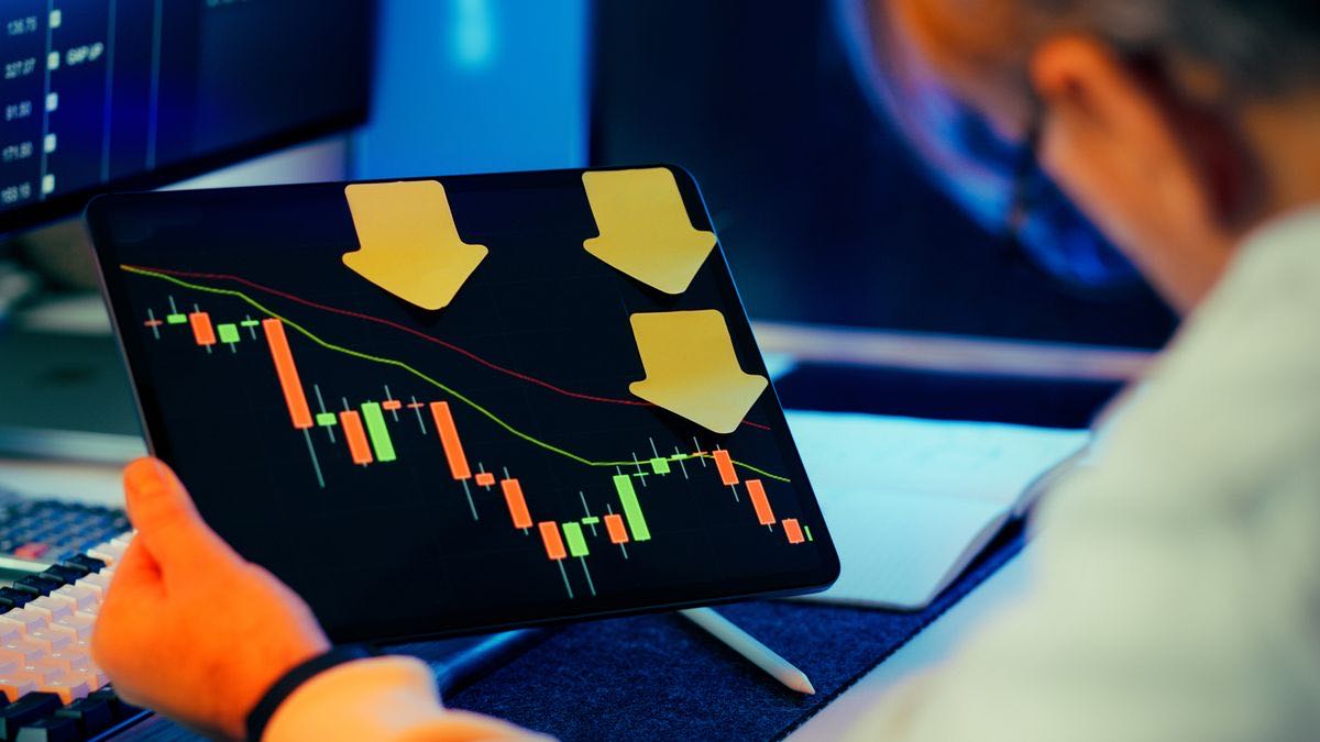 A close view of a financial screen with falling price lines, representing the price comparison step of an alert loop