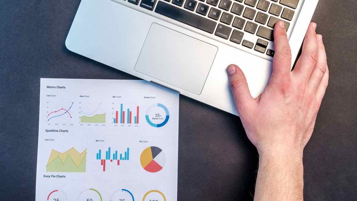 A laptop beside printed charts on a desk, representing a clean data workflow behind a thin provider adapter