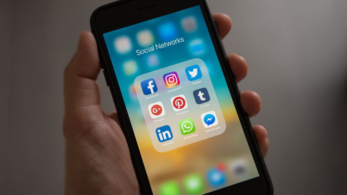A phone showing a social networks folder with the Instagram icon, representing scraping Instagram for free
