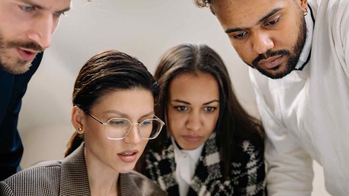 A group of professionals studying results together on screen, acting on a hiring-intelligence feed