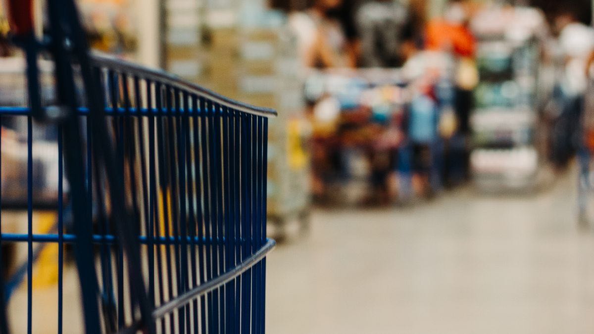 Product boxes stacked in a shopping cart, illustrating the product listing data a scraping script collects