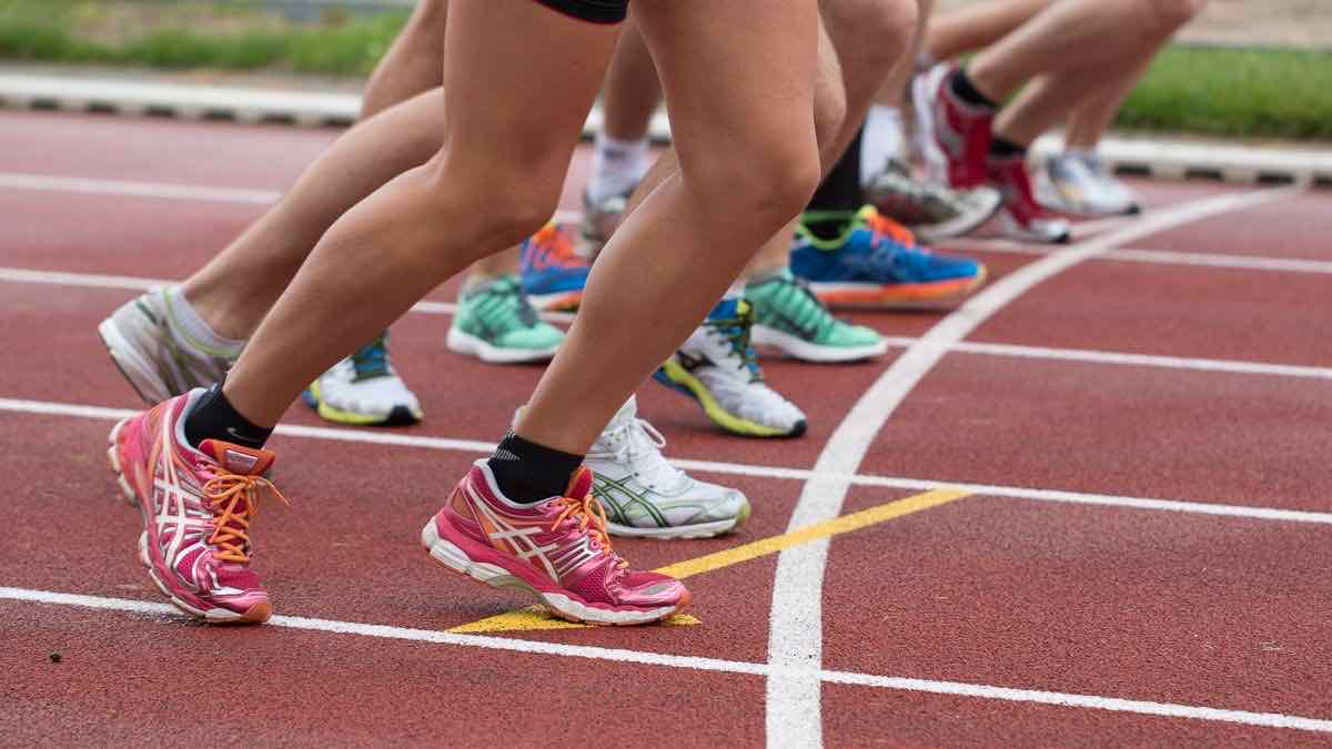 A row of runners launching off a track start line together, representing concurrent Go workers
