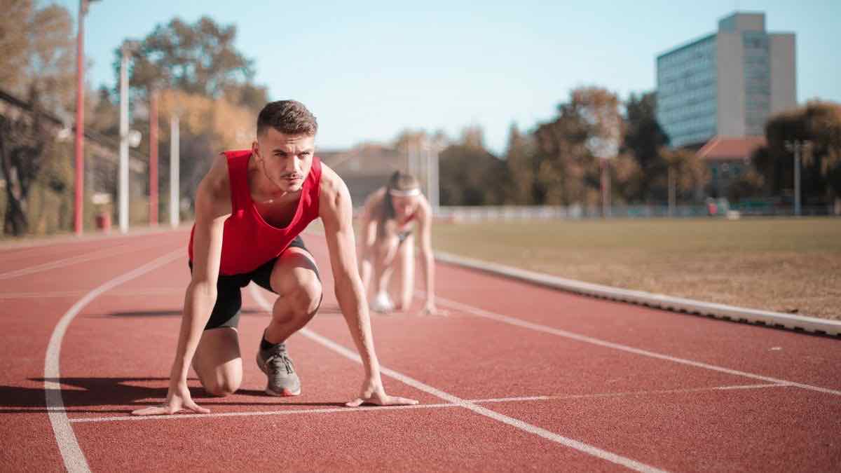 A sprinter crouched in the set position on a running track, representing getting started with Go