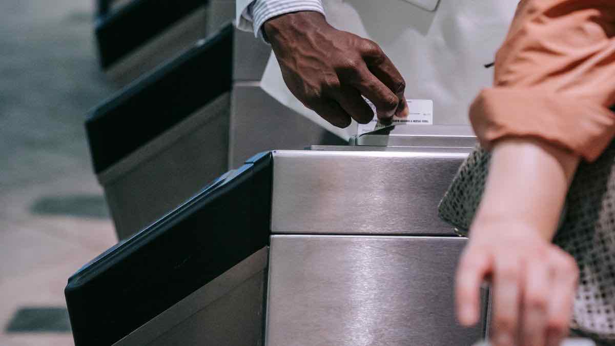 A commuter tapping a card at a subway turnstile, representing requests being admitted one at a time