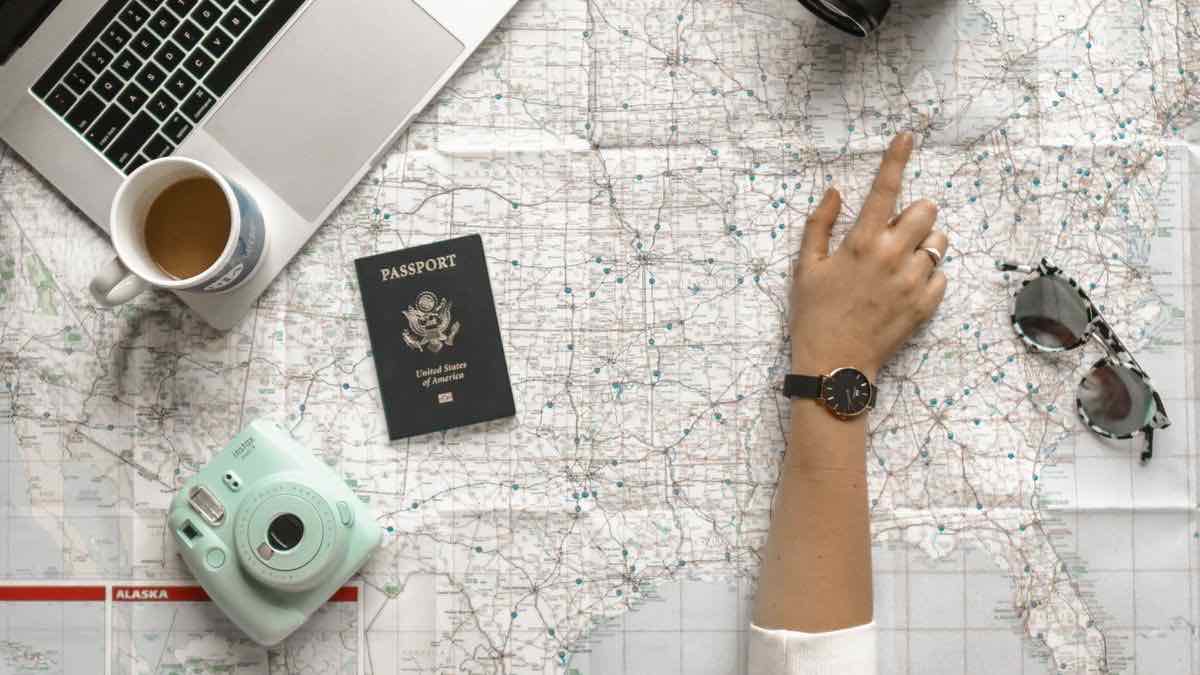 A finger pointing at one exact spot on a paper map of the United States