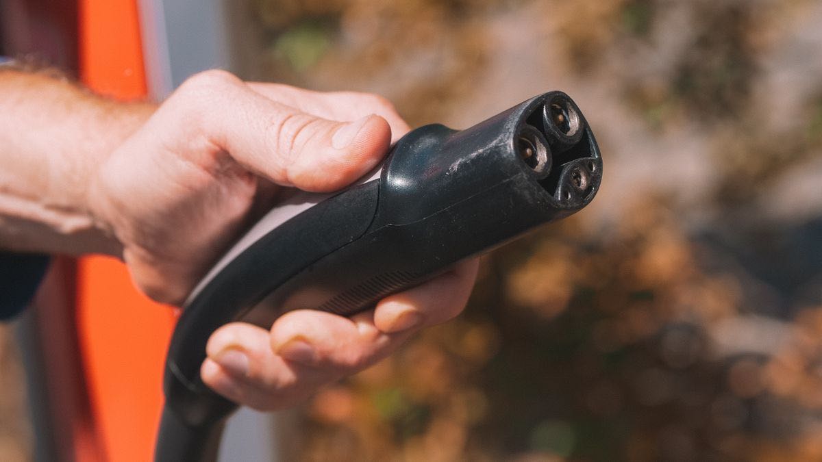A hand holding a charging plug ready to connect, a metaphor for plugging live web search into an AI application